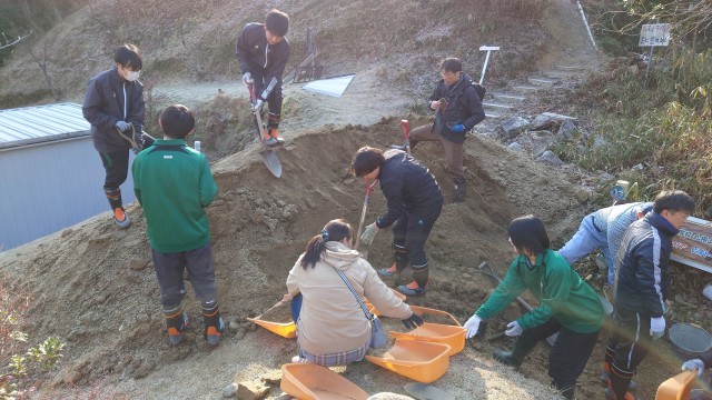 凍った土山をスコップで崩す